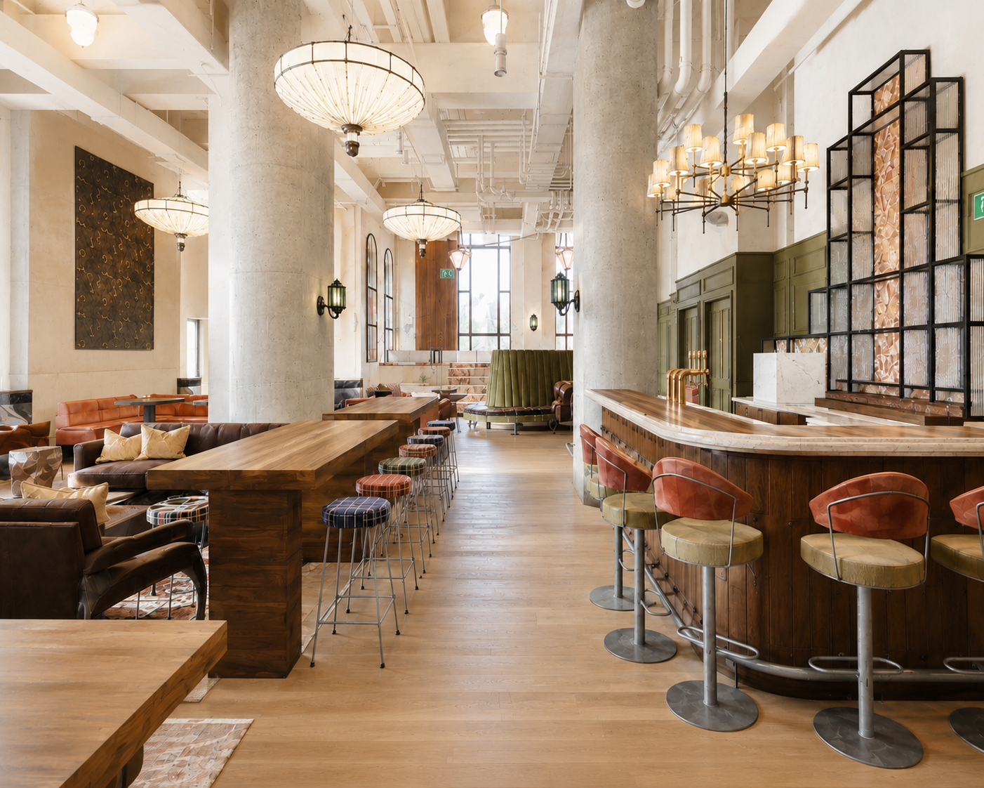 Upscale bar lounge with long wooden tables, colorful stools, and tall concrete columns in a bright, open space.