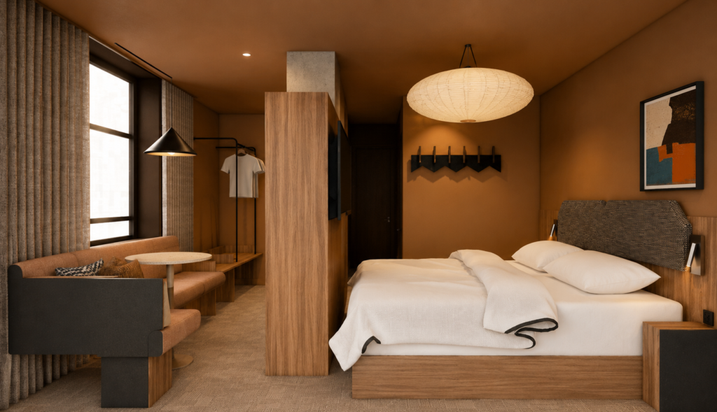 Warm hotel room with a king bed, wooden headboard, and a seating nook by a large window.